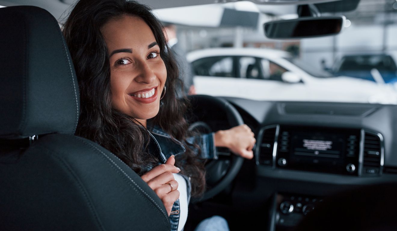 Imagem mostra pessoa dentro de um carro novo