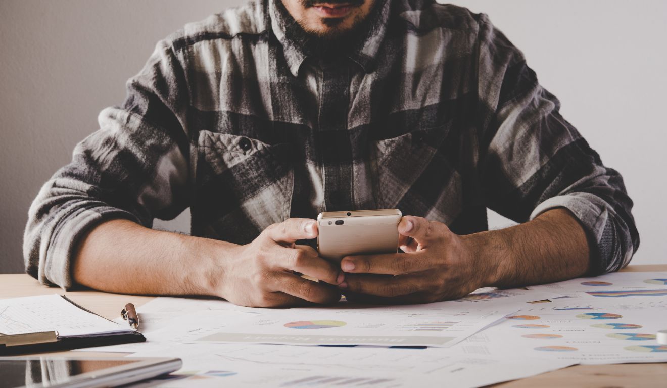 Imagem mostra uma pessoa usando um app de organização financeira