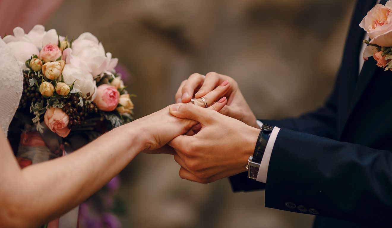 Casal trocando alianças durante uma cerimônia de casamento.
